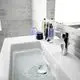 Elegante Waschtischarmatur von Ideal Standard mit verchromter Oberfläche, die Wasser in das Waschbecken leitet. Auf der Ablage befinden sich mehrere Pflegeprodukte.
